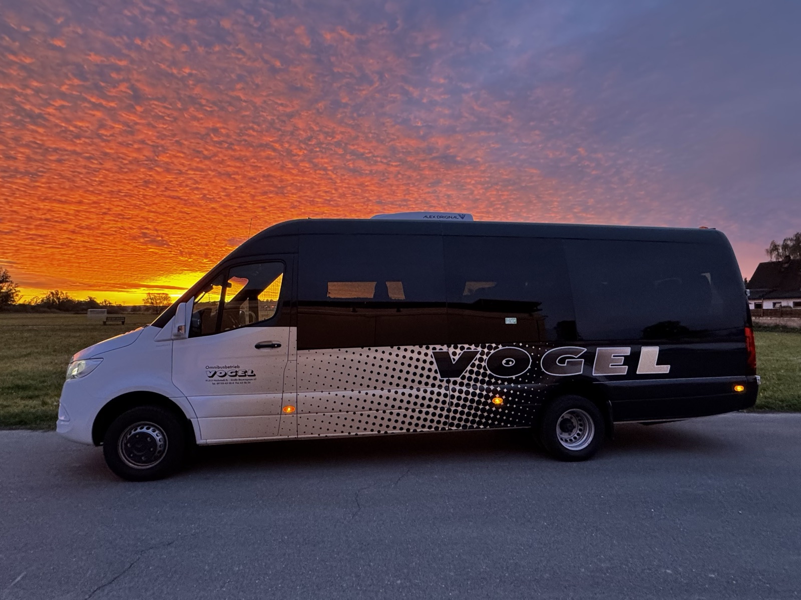Komfort Midibus von Vogel-Omnibus in der Seitenansicht vor einem Abendrot