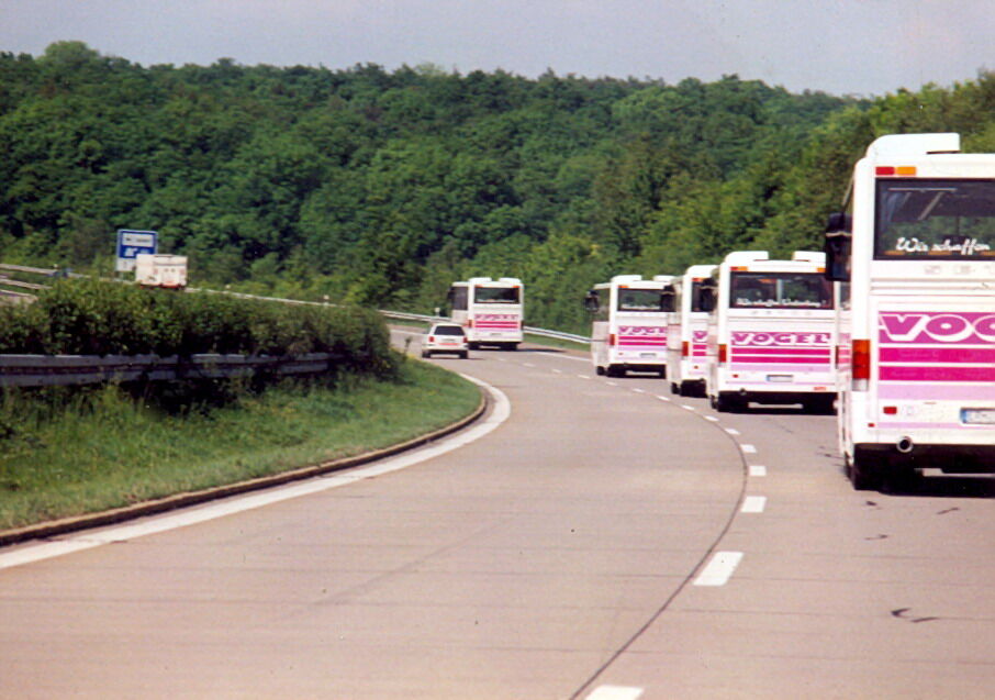Buskolonne von Vogel-Omnibus unterwegs auf der Autobahn