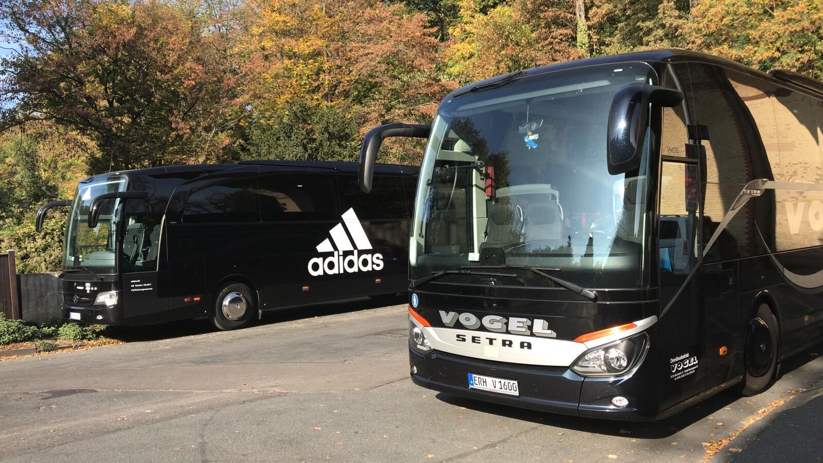 Vogel-Reisebus neben dem adidas-Mannschaftsbus