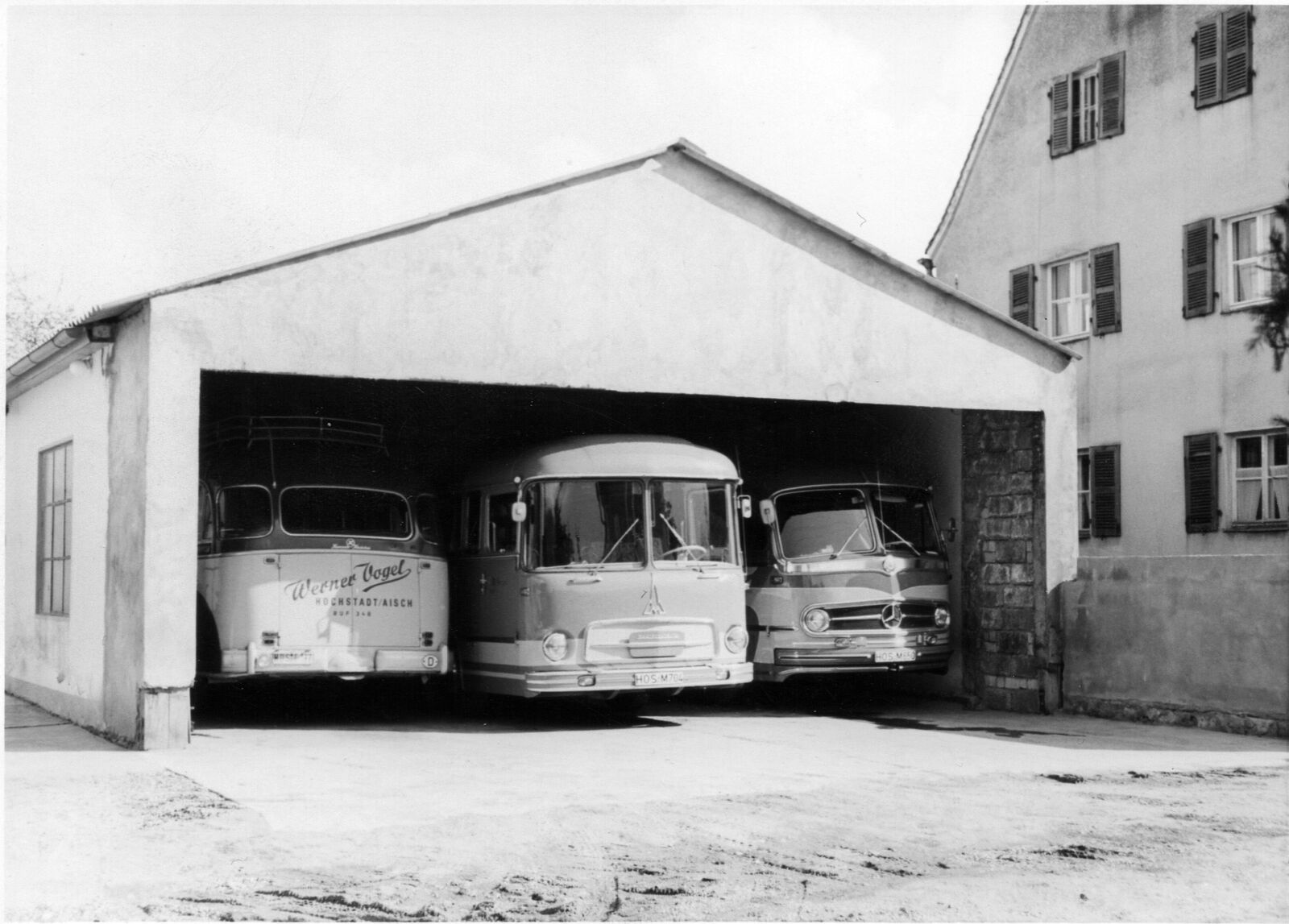 Schwarz-Weiß-Aufnahme der ersten Wagenhalle mit drei Omnibussen in der Dr.-Schätzel-Straße