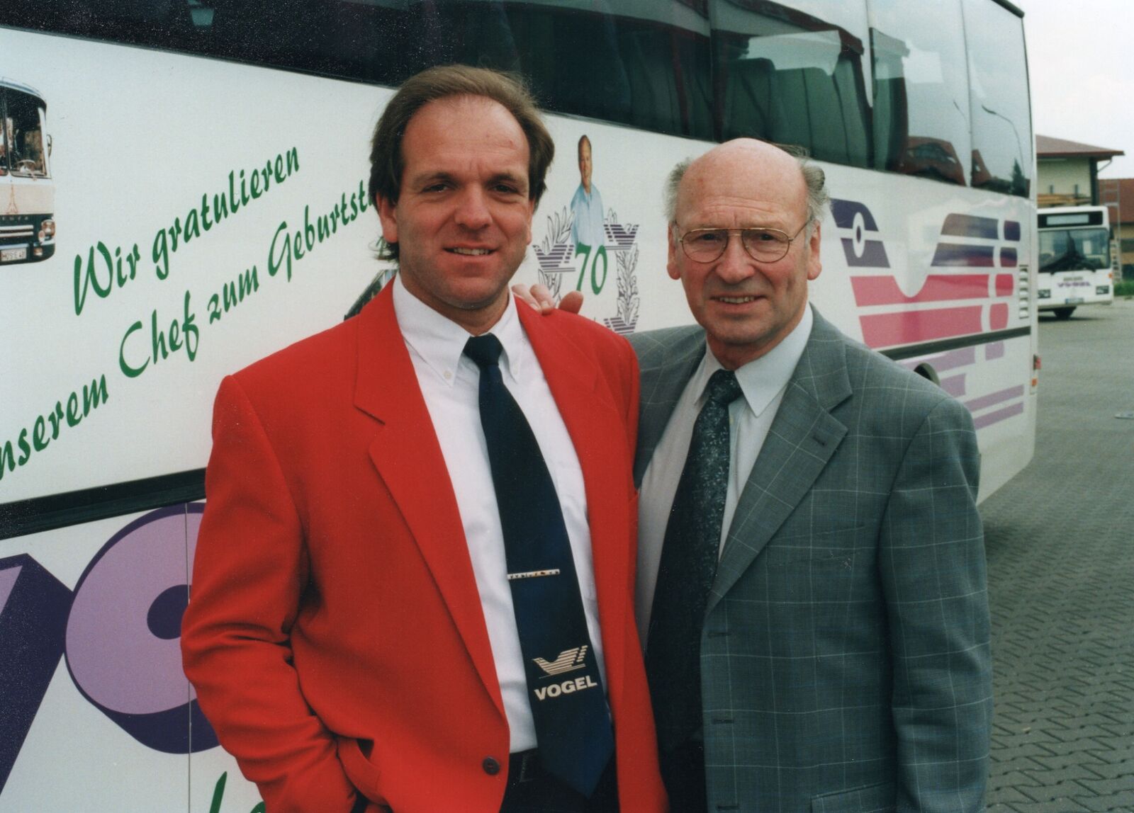 Werner Vogel senior und Werner Vogel junior vor einem Reisebus bei der Übergabe des Familienunternehmens an die nächste Generation im Jahr 2000